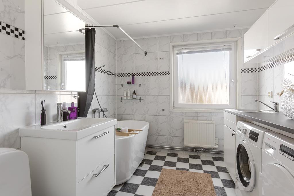 Kombinerat badrum och tvättrum med tvättmaskin och torktumlare