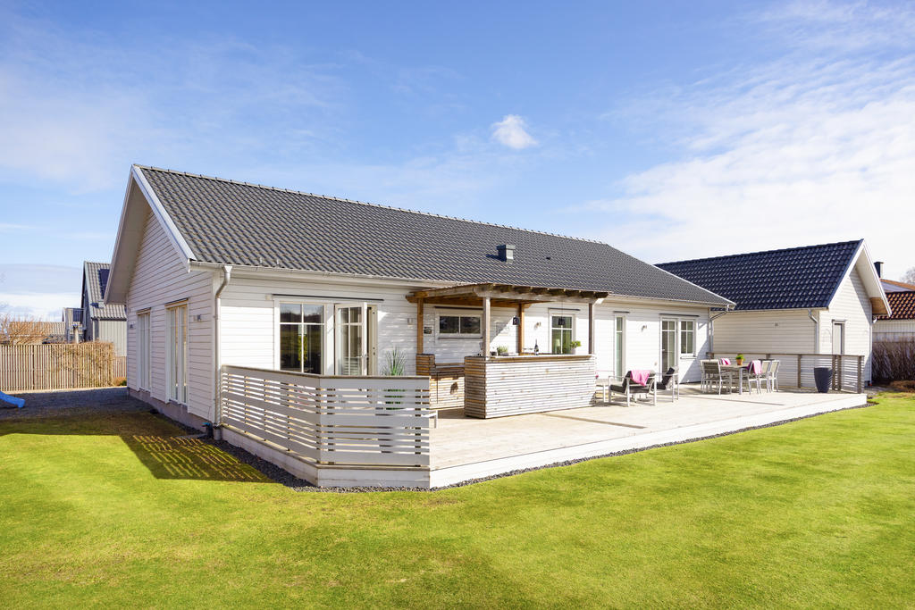 Stor uteplats med plats för matplats, loungegrupp och solsängar. 