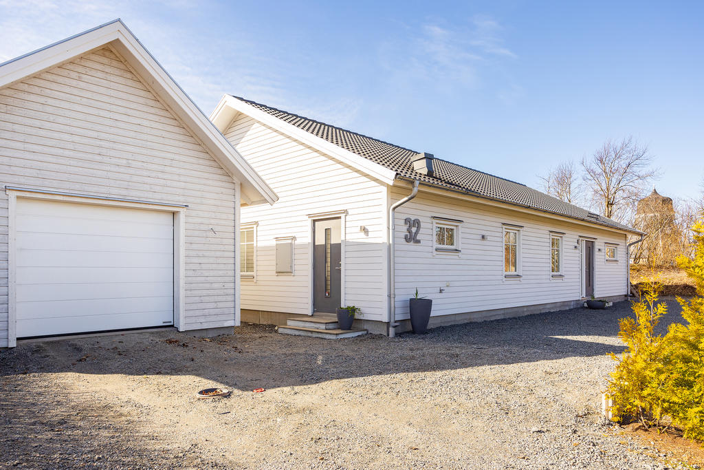 Fristående garage och uppfart med plats för flera bilar.