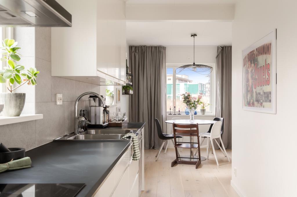 Kök med öppen känsla mot matplats och vardagsrum.