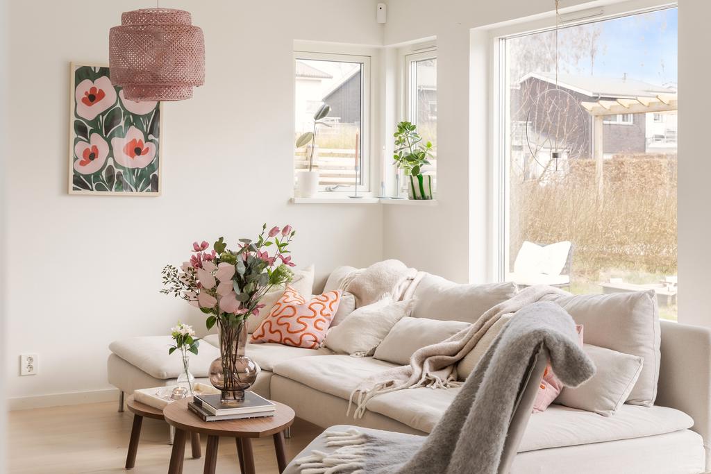 Vardagsrum med stora fönsterpartier och utgång till altan.