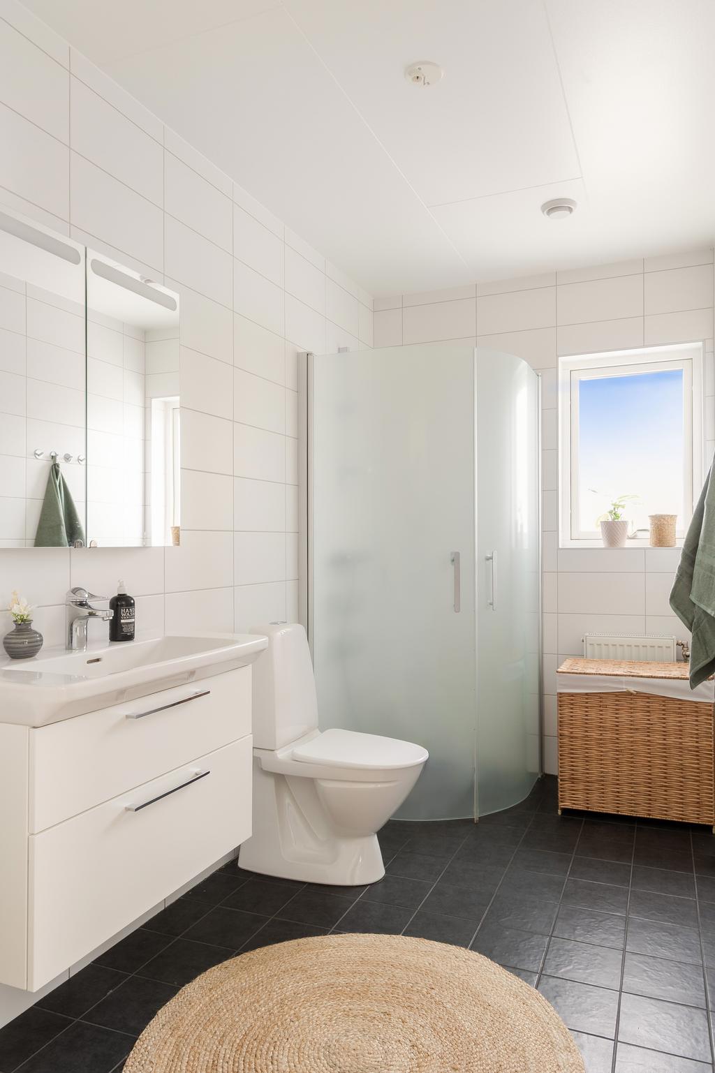 Helkaklat badrum med dusch på övre plan.