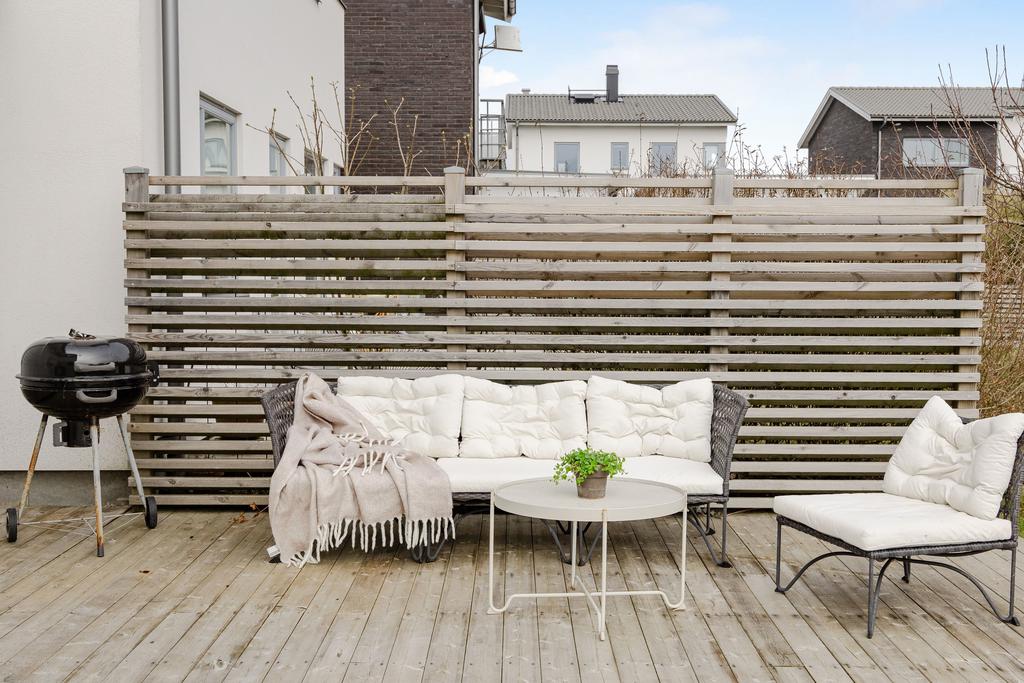 Skyddad uteplats med plats för loungemöbler.