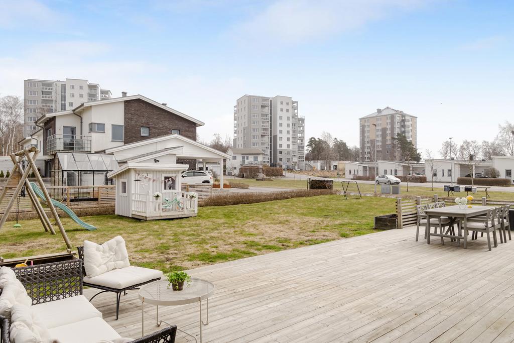 Trädgård med gott om plats för utemöbler och aktiviteter.