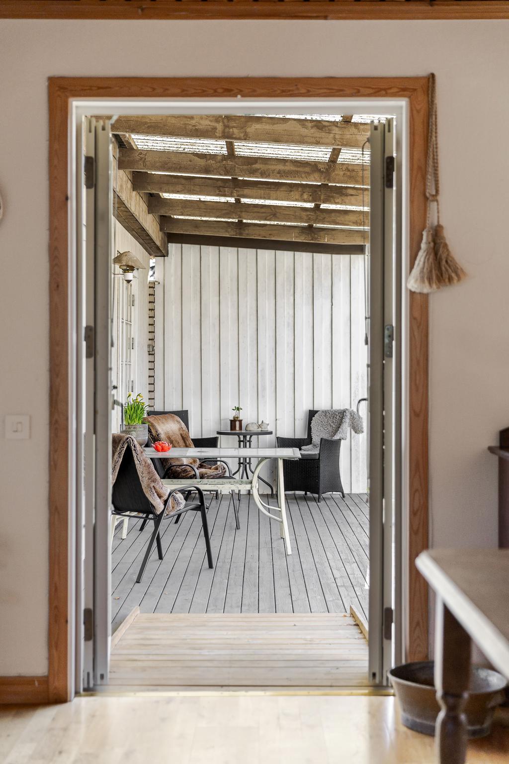 Utgång till takad altan och trädgård