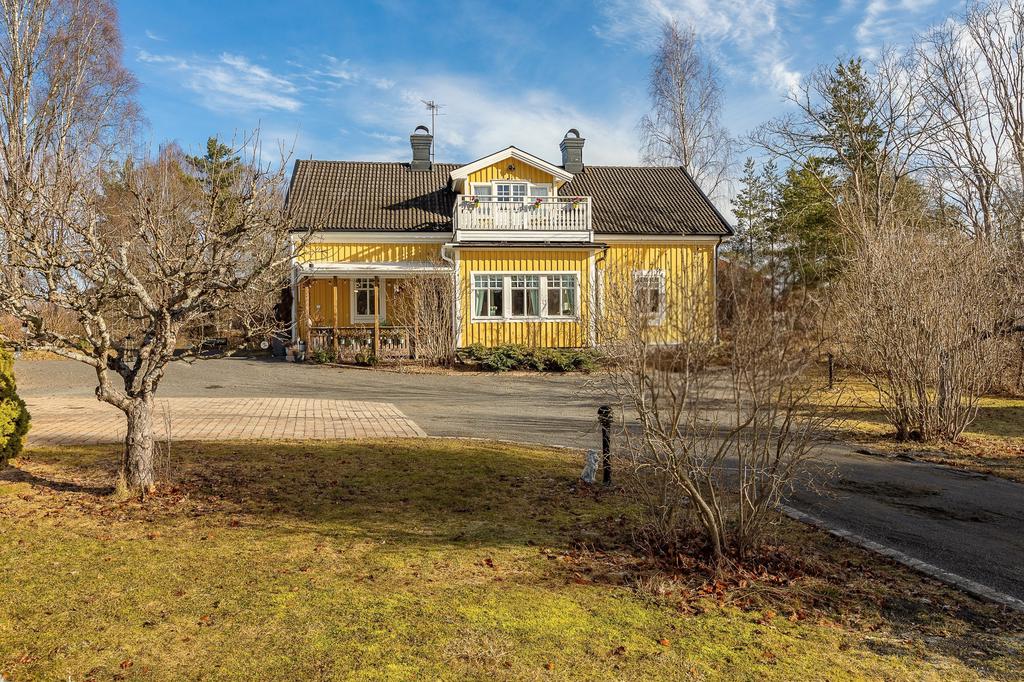 Framsida med stor balkong och altan under tak