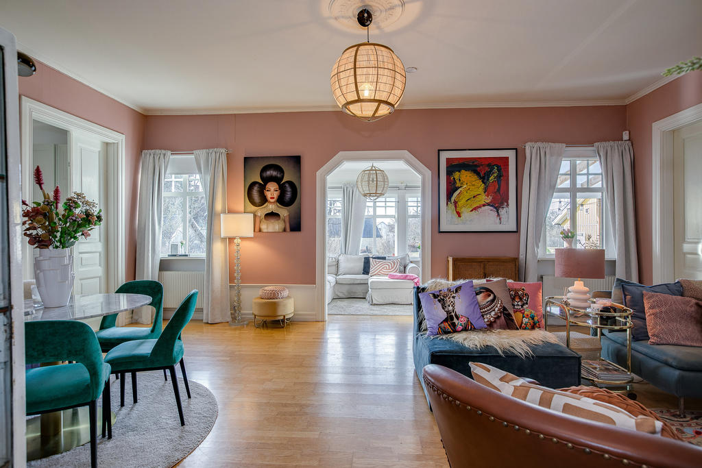 Vardagsrum med utsikt in till rum som vetter ut mot framsidan av tomten och har dörr ut till altanen under tak