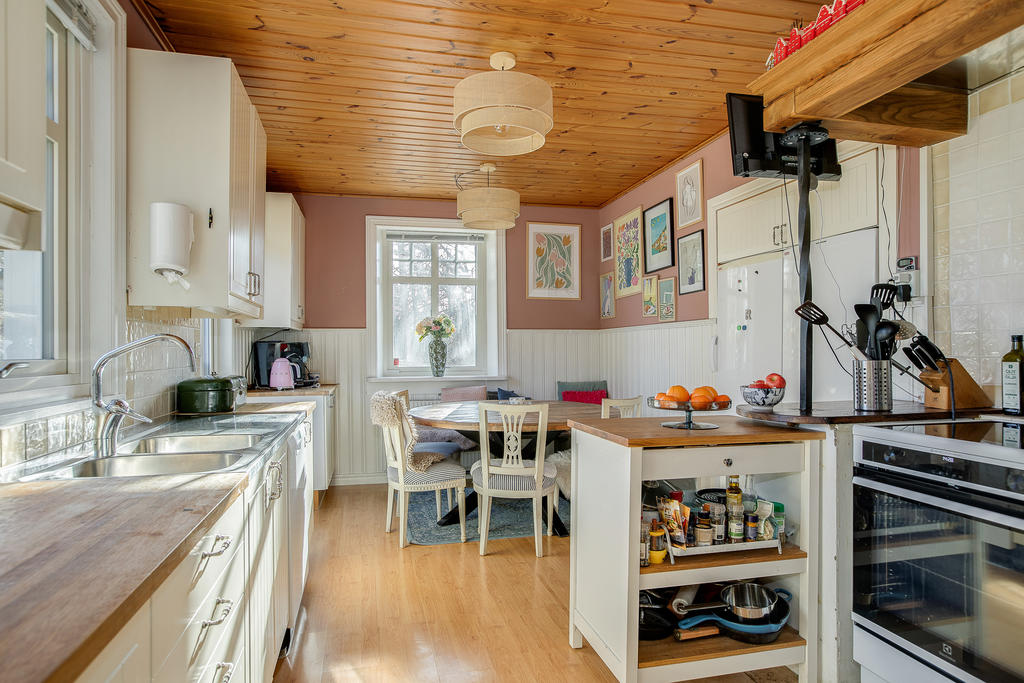 Kök med stor kyl och frys samt dörr ut till altan och den stora bakgården