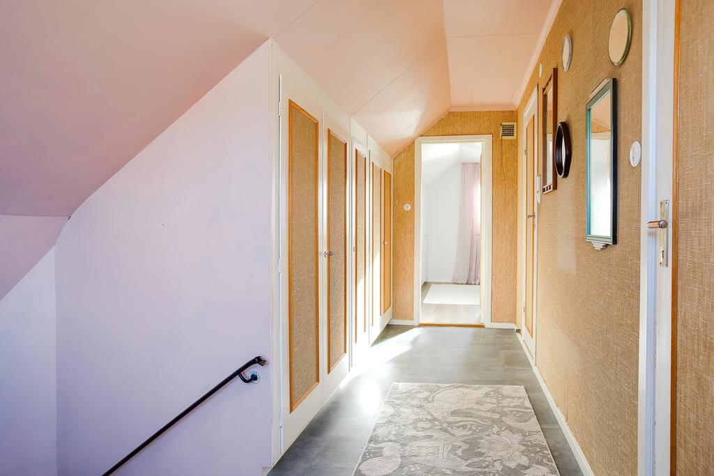 Hall på ovanvåning med dörr ut till balkong