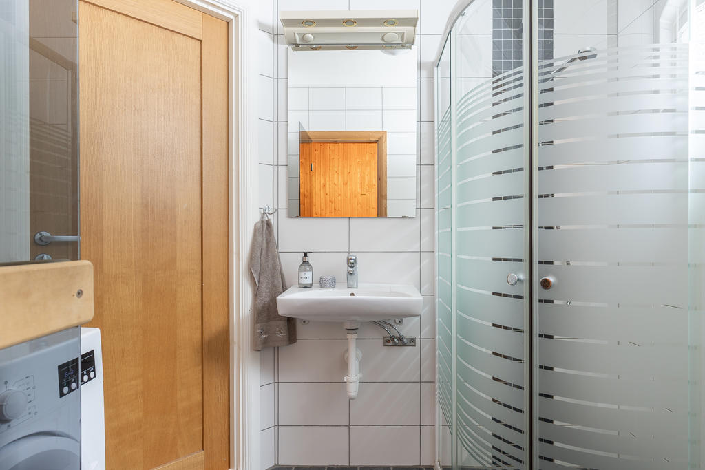 Helklaklat badrum med tvättmaskin och bastu.