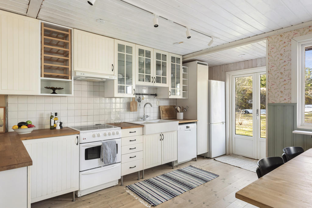 Köksdel som har bra med skåpsförvaring och arbetsbänkar