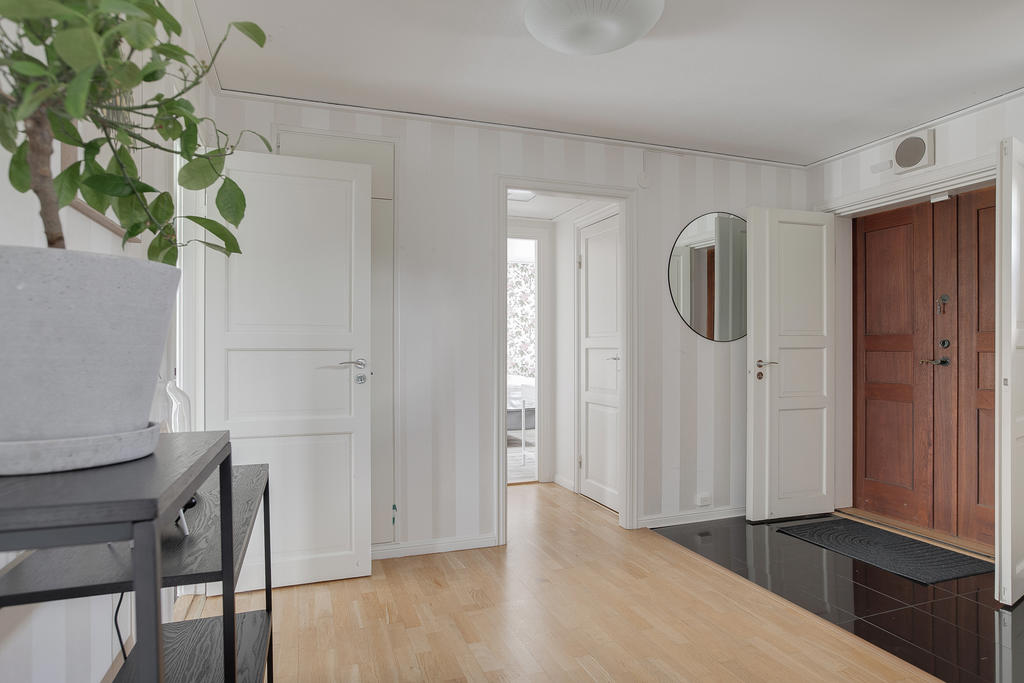 Rymlig hall med klinker vid ingång