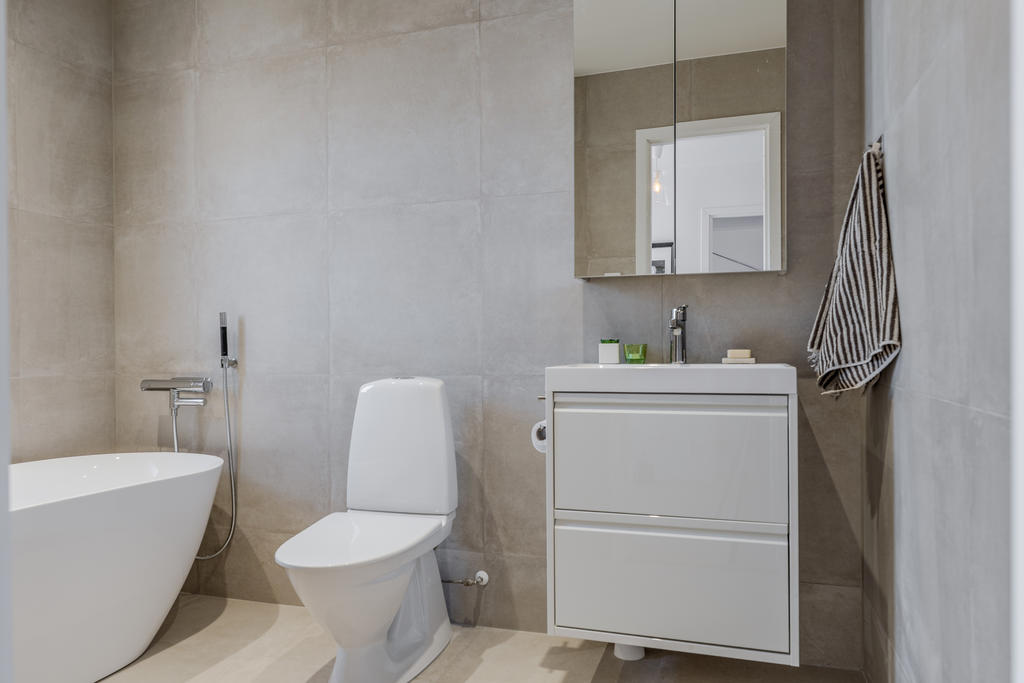 Badrum med helkaklade väggar och klinkergolv 