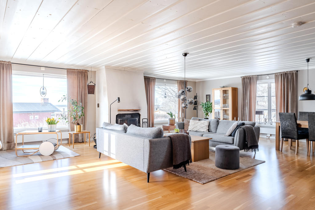 Underbart vardagsrum med öppen spis  och stora fina fönster