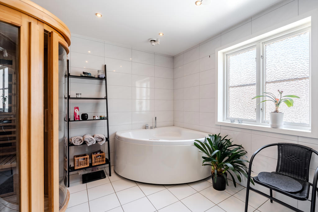 Lyxigt badrum med stort badkar och bastu