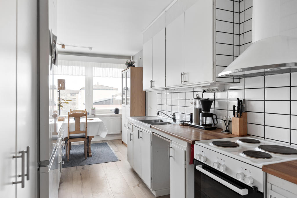 Ljust kök med matplats vid fönstret mot gården