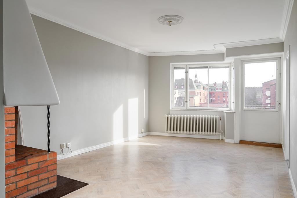 Vardagsrum med utgång till balkong i söder samt öppen spis