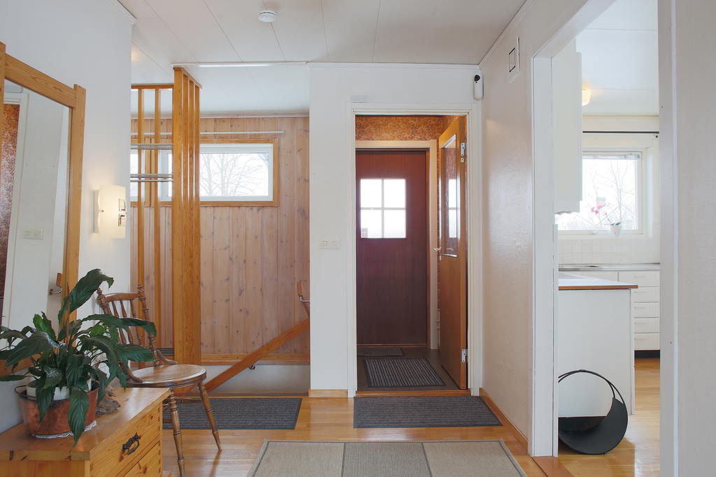 Ingång till vindfång med större hall i anslutning. Trappa till källarplan nås här 