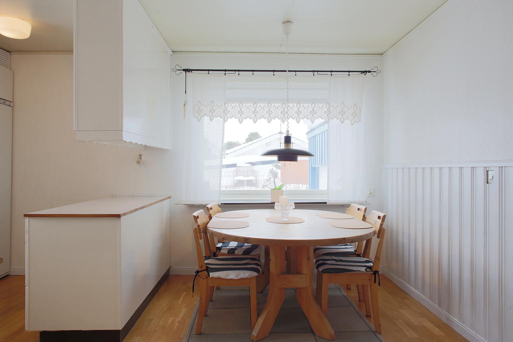 Ljust kök med plats för matbord vid fönstret 