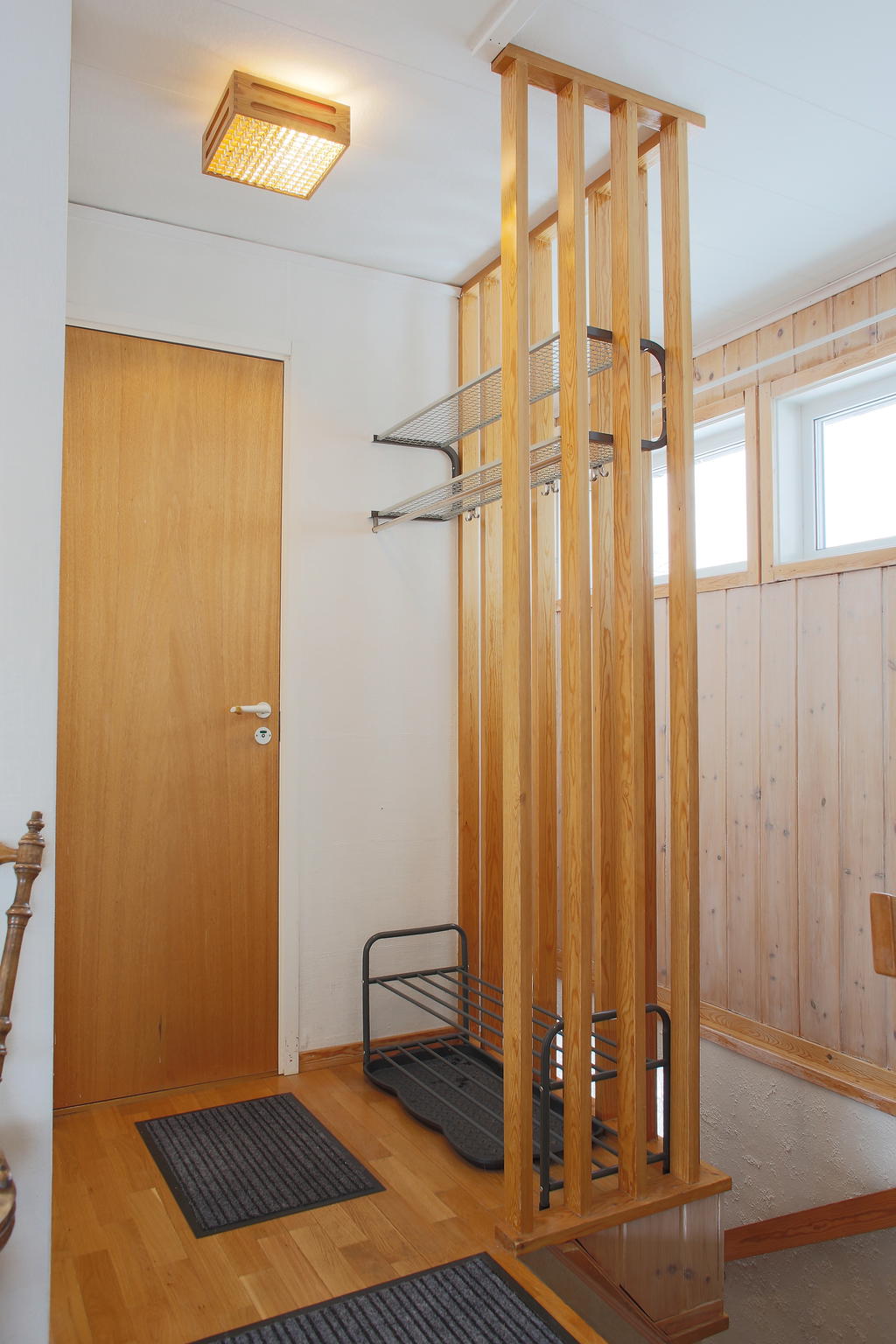 Hall med hatthylla och dörr till toalett