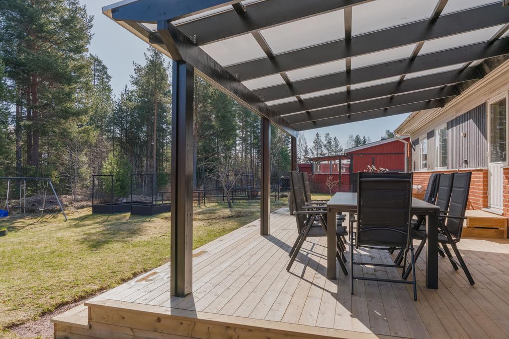 Stort atandäck, delvis med tak, mot trädgården