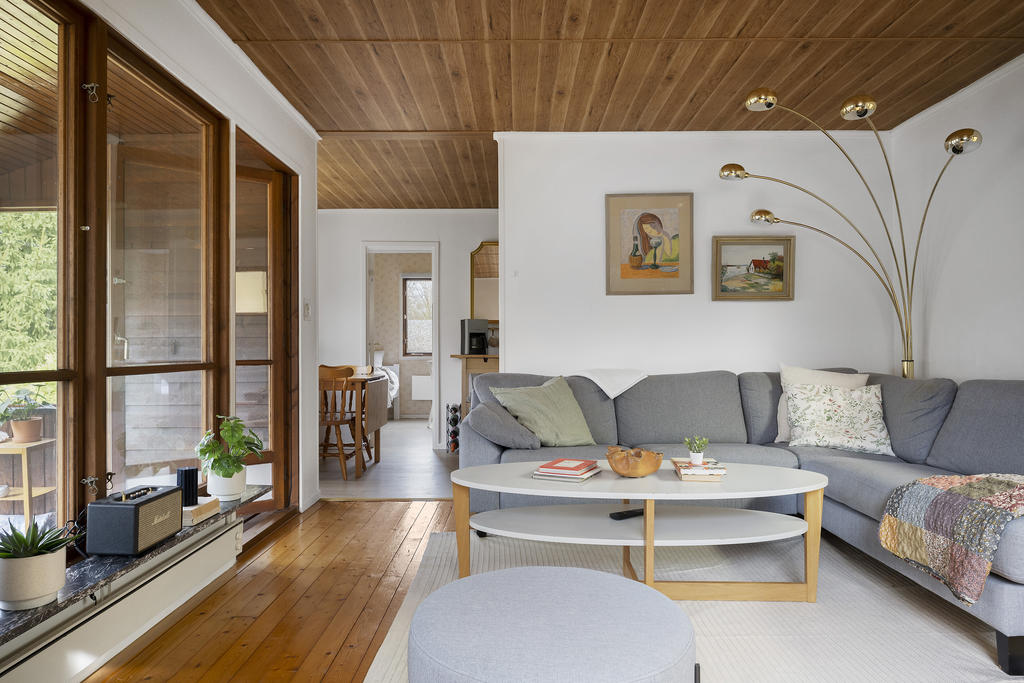 Vardagsrum med stora fönsterpartier samt altandörr ut till altanen