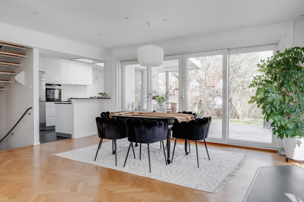 Matplats med stora öppningsbara fönsterpartier ut mot den mysiga altanen på husets baksida.