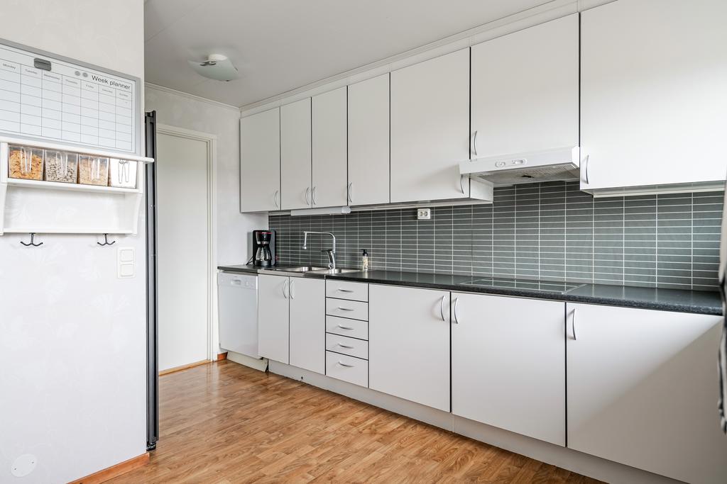 Vy över det stilrena köket som är i klassiskt vitt. 