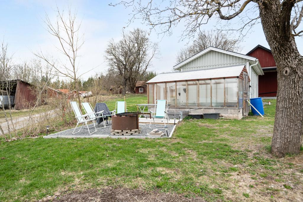 Vid sidan av huset finns en otroligt mysig grill-plats och växthus. 