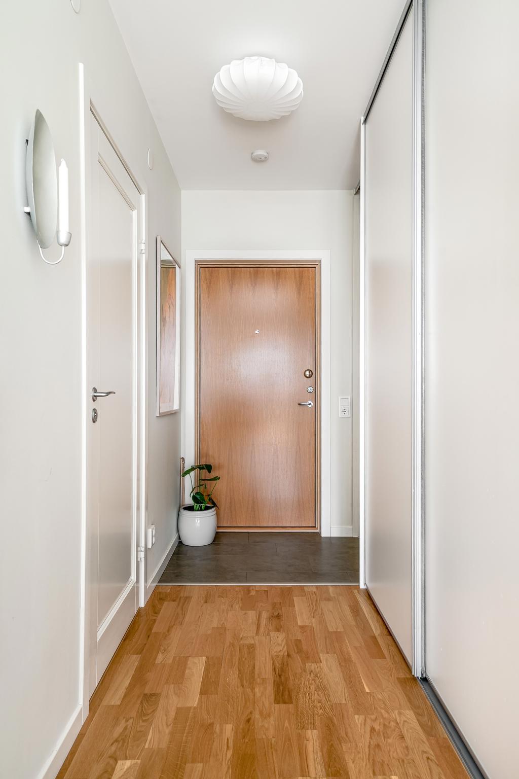 Hall med skjutdörrsgarderober för praktisk förvaring