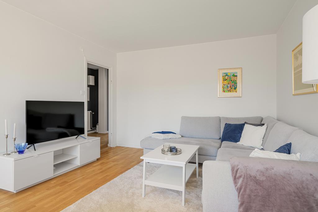 Vardagsrum med ljusa väggar och ekparkett