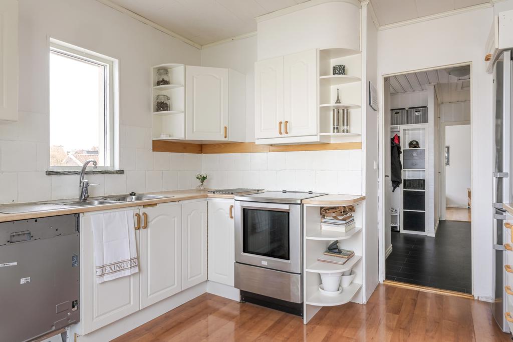 Vita köksluckor och handtag i trä