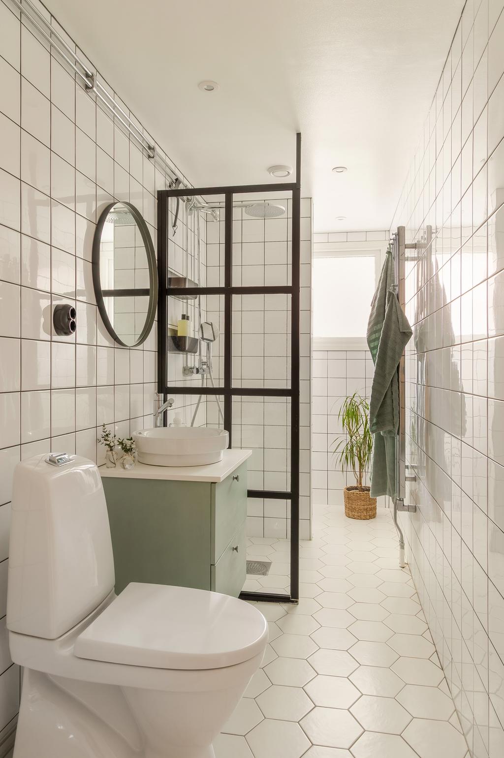 Stilrent och modernt helkaklat badrum med industrikänsla. 