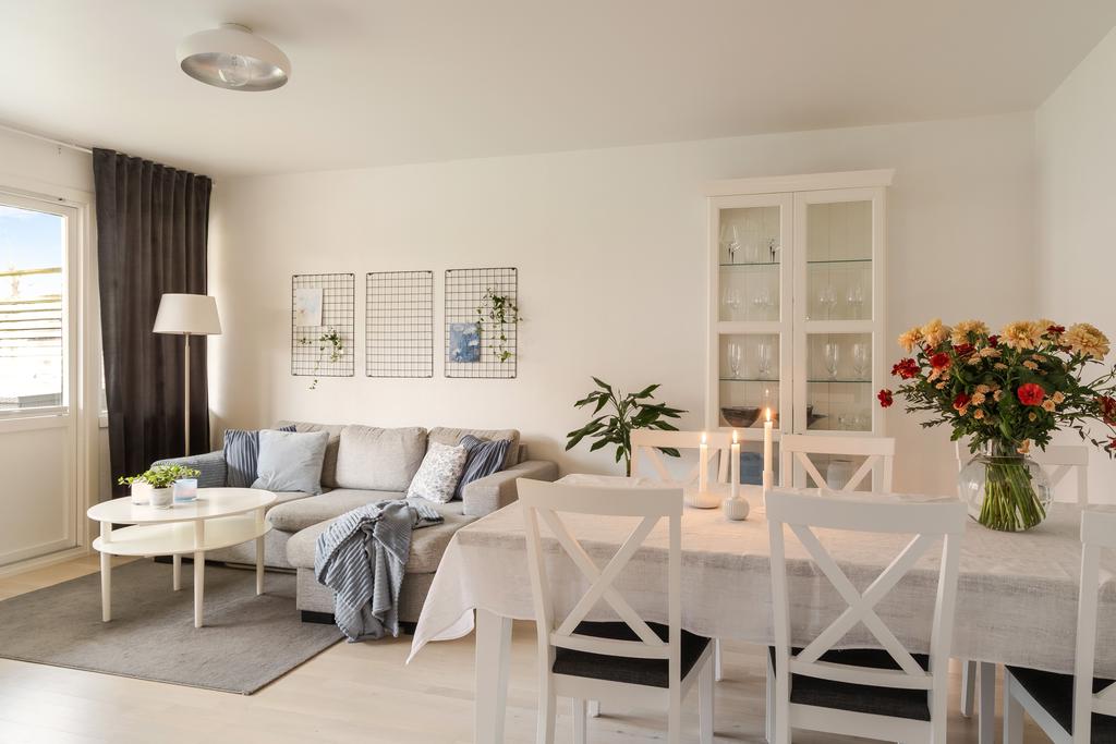 Ljust och luftigt vardagsrum med stora fönsterpartier som släpper in rikligt med dagsljus.