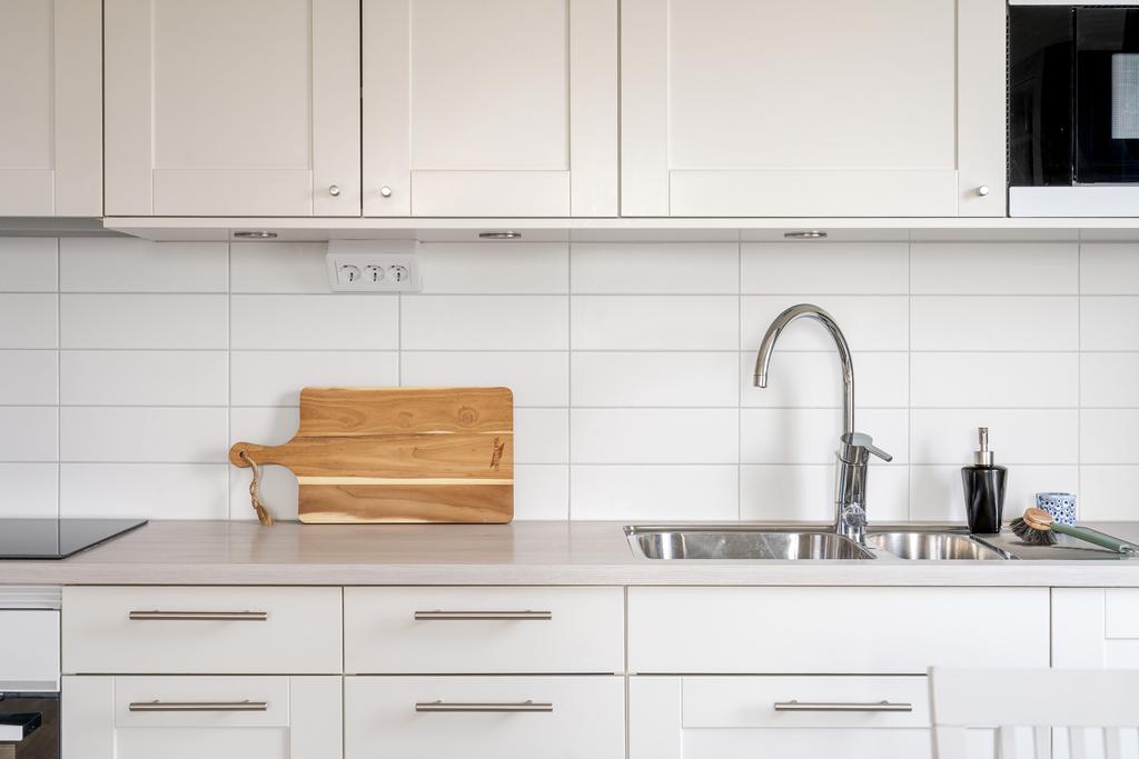 Bänkskiva i ljus laminat och kaklat stänkskydd