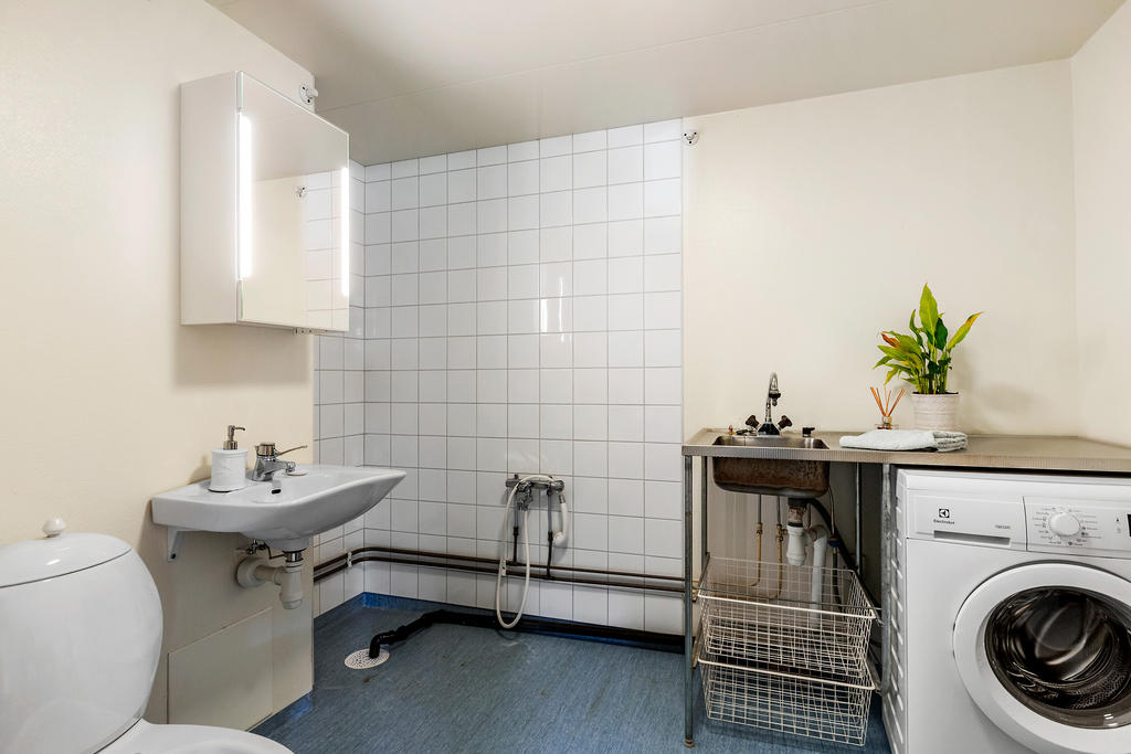 I anslutning till hallen återfinns bostadens första badrum / tvättstuga 