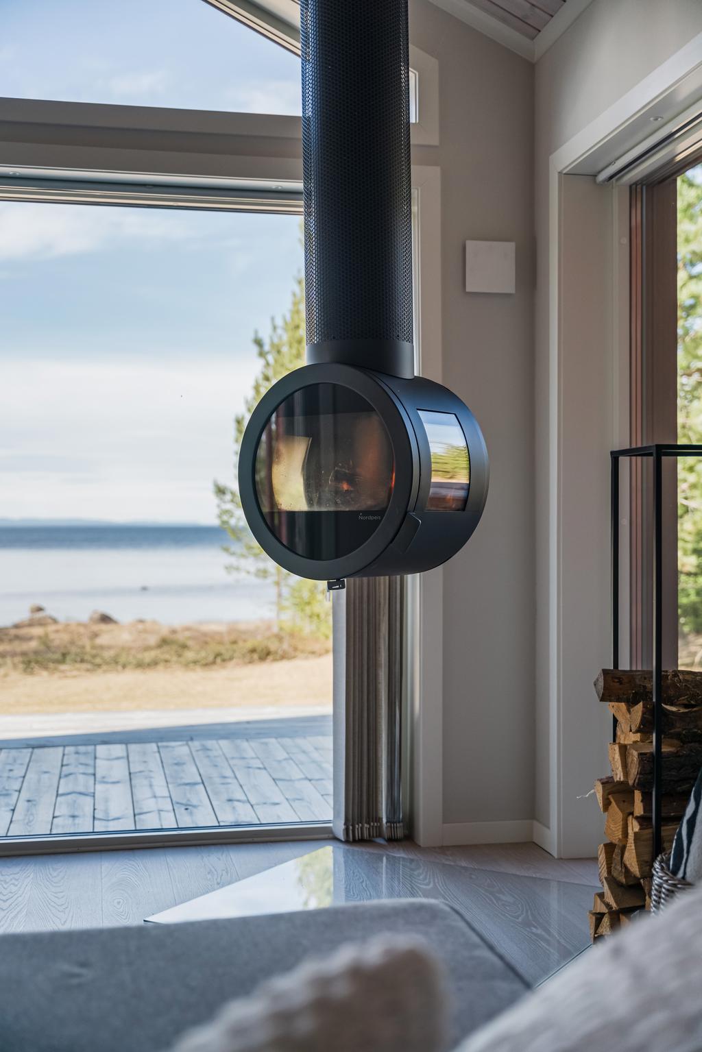 En modern kamin som blir en naturlig samlingspunkt, med vacker utsikt mot Siljan.