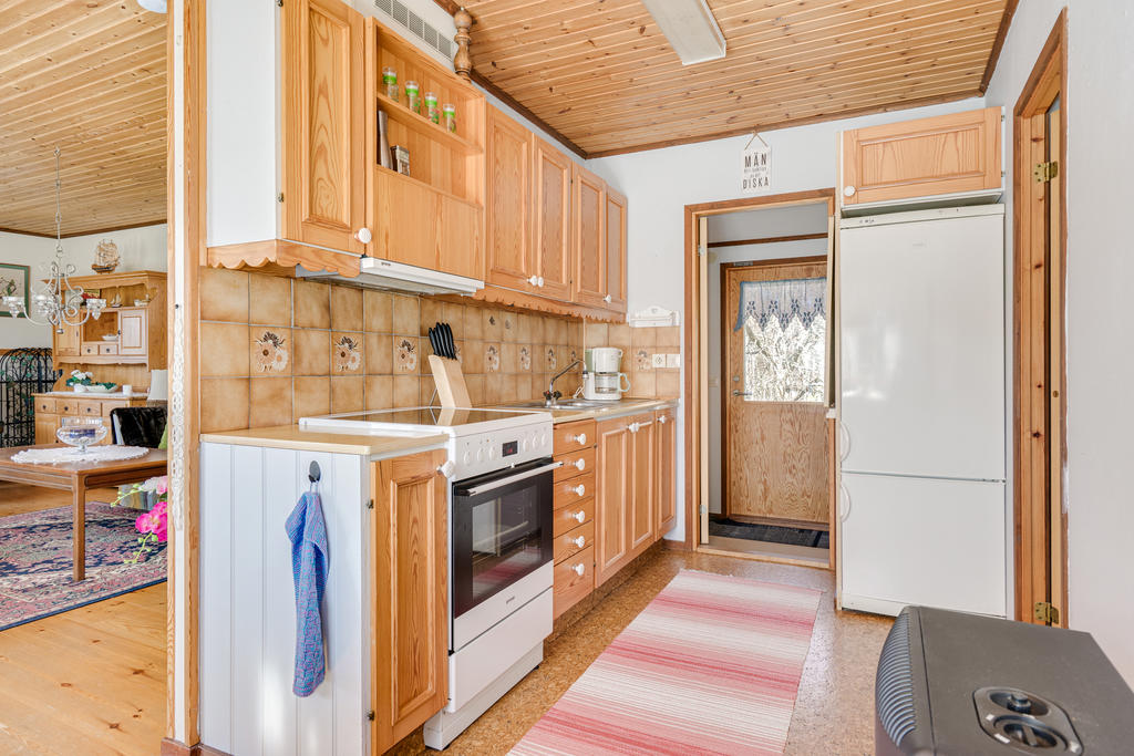 Funktionellt kök med plast för matbord och utgång till trädgård.