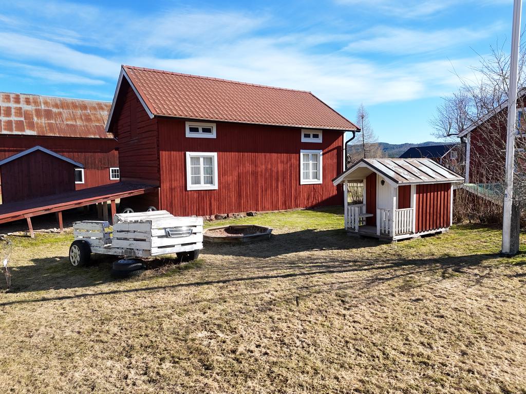 På baksidan så finner du en gullig liten lekstuga och en sandlåda. 