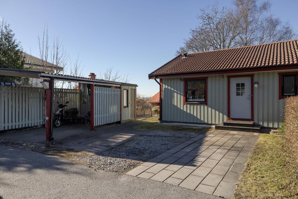 Uppfart med plats för två bilar samt carport och ett isolerat förråd med fönster.  