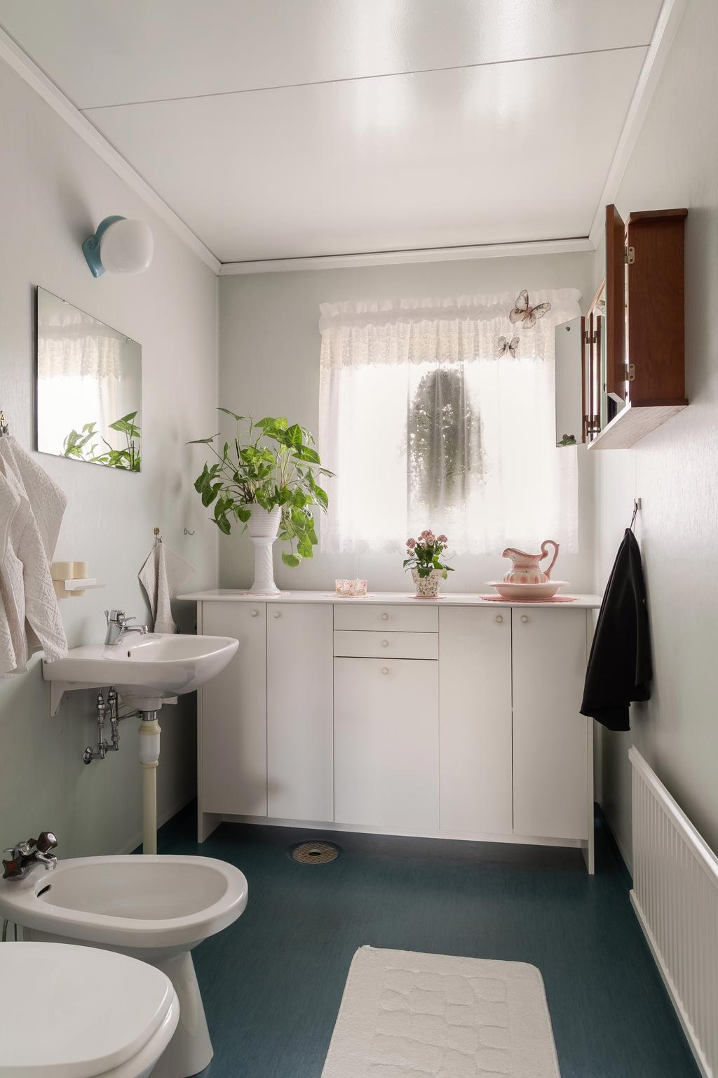 Badrummet på entréplan. Plastmatta i original på golv och väggar.