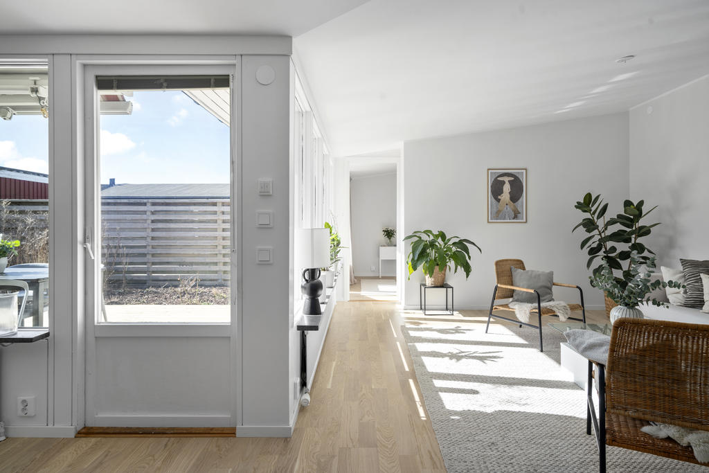 Generösa fönsterpartier skapar ett härligt ljusinsläpp och bidrar till en inbjudande och trivsam atmosfär i vardagsrummet och matplatsen