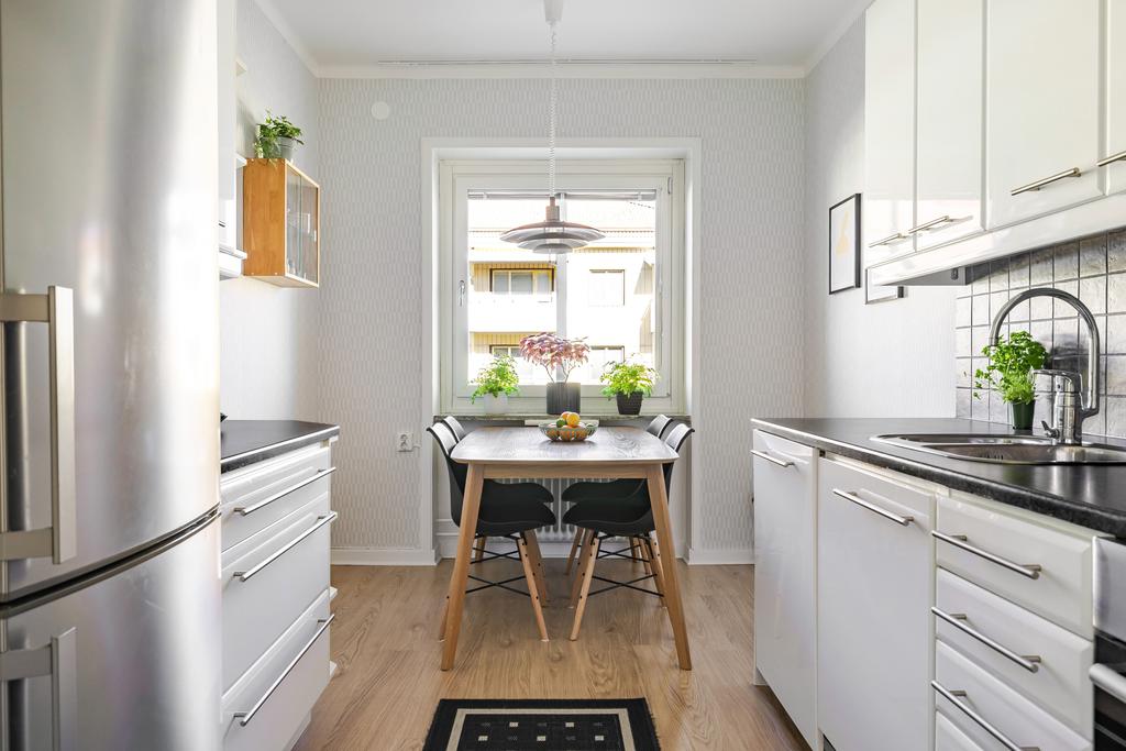 Kök med mycket arbetsyta och plats för matgrupp.