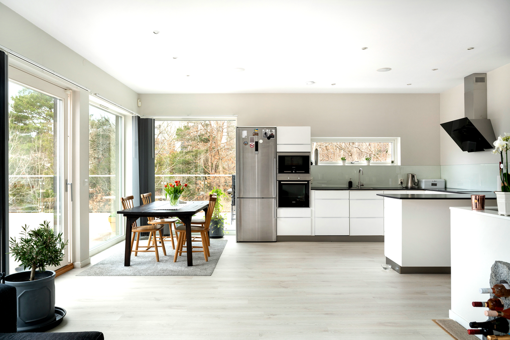 Kök och vardagsrum i öppen planlösning ger stora sociala ytor