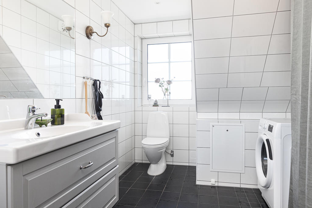 Helkaklat badrum med dusch och tvättmaskin