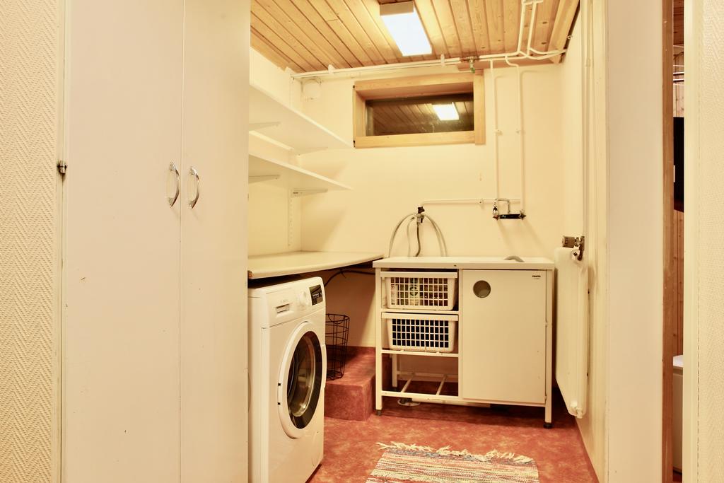 Tvättmaskin, tvättho, hyllor och bänkar i tvättavdelningen 