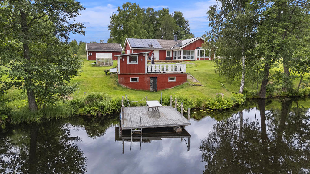 Uthus med förrådsutrymmen samt uteplats intill bryggan