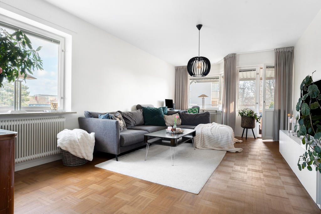 Generöst vardagsrum med fönster i flera väderstreck