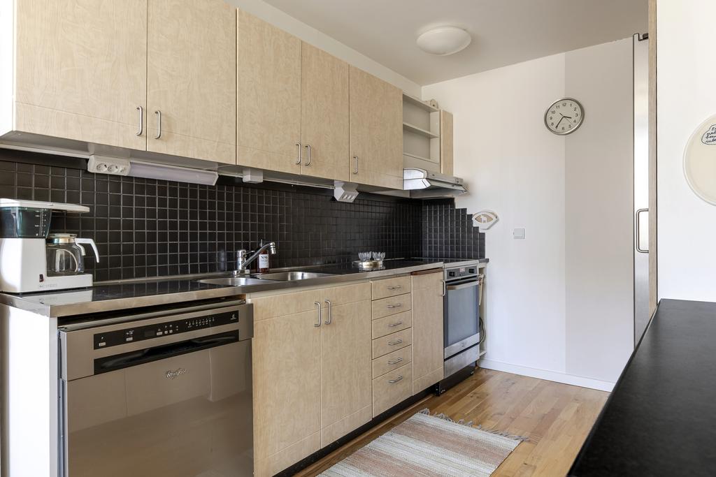 Kök med svart kakel och ljusa luckor 