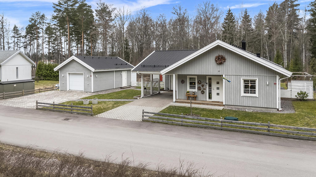 Entrésidan med båda garage och carport